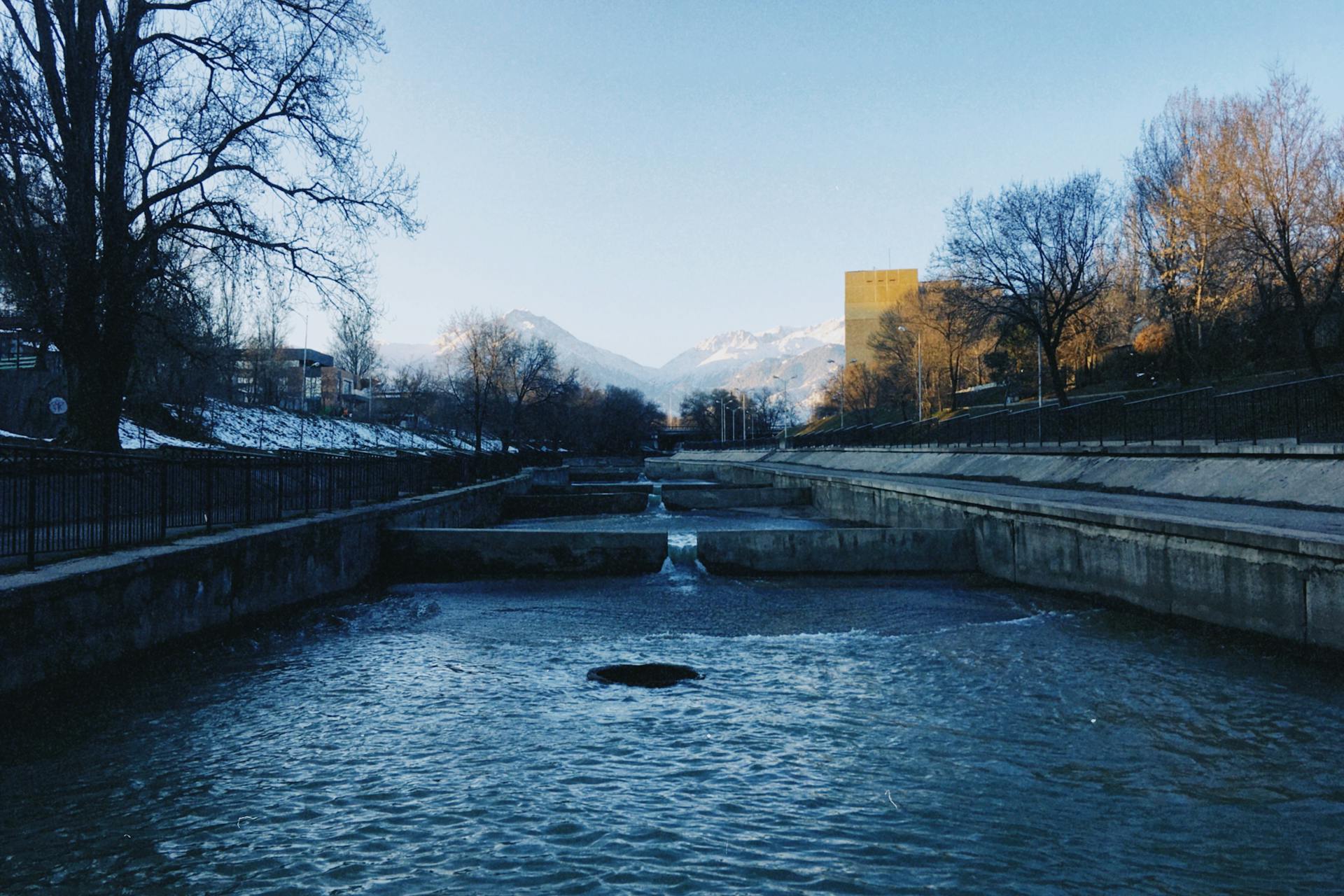 River promenade with snow-capped mountains above Almaty, Kazakhstan