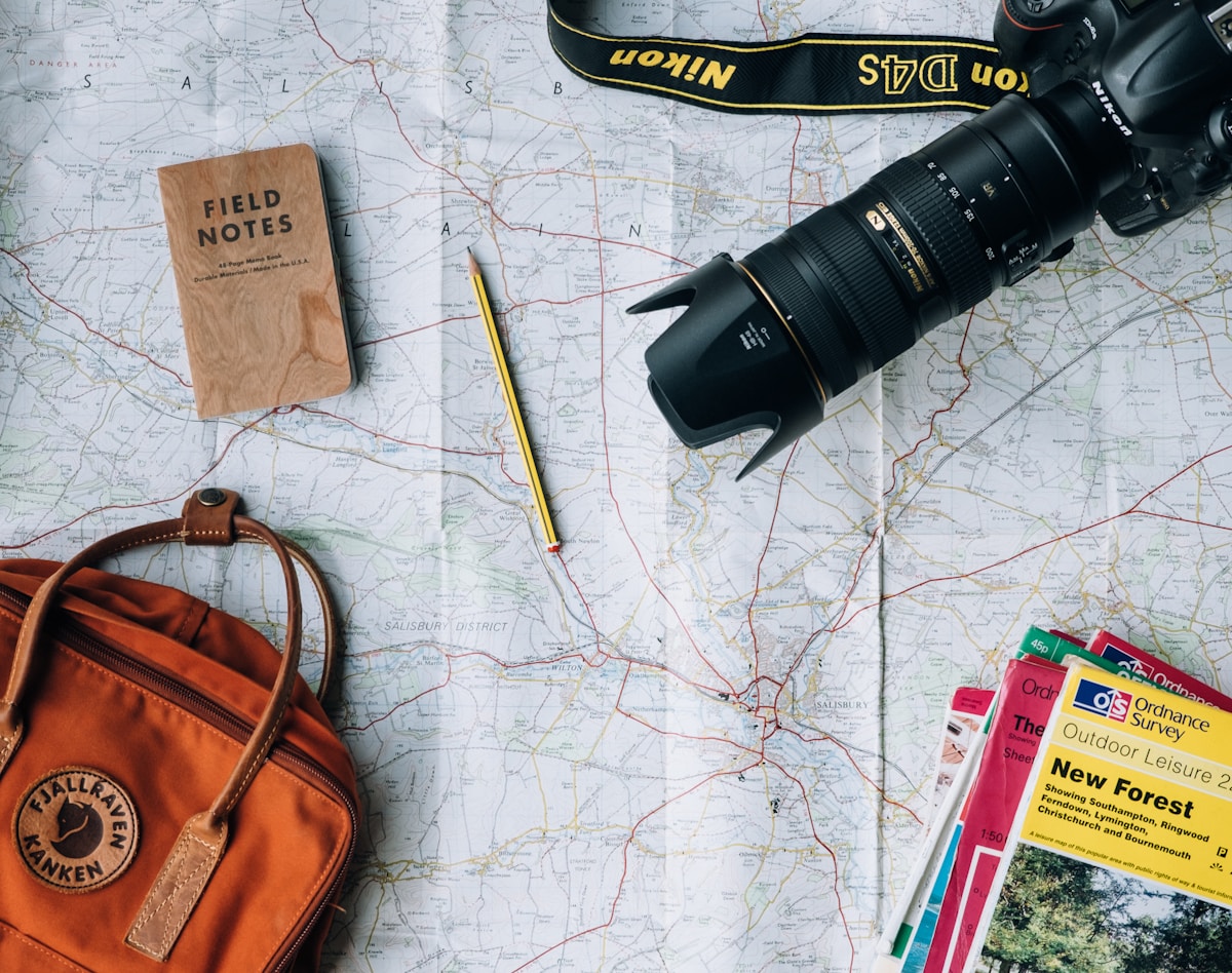 Travel planning with a map, notebook, and camera on a table